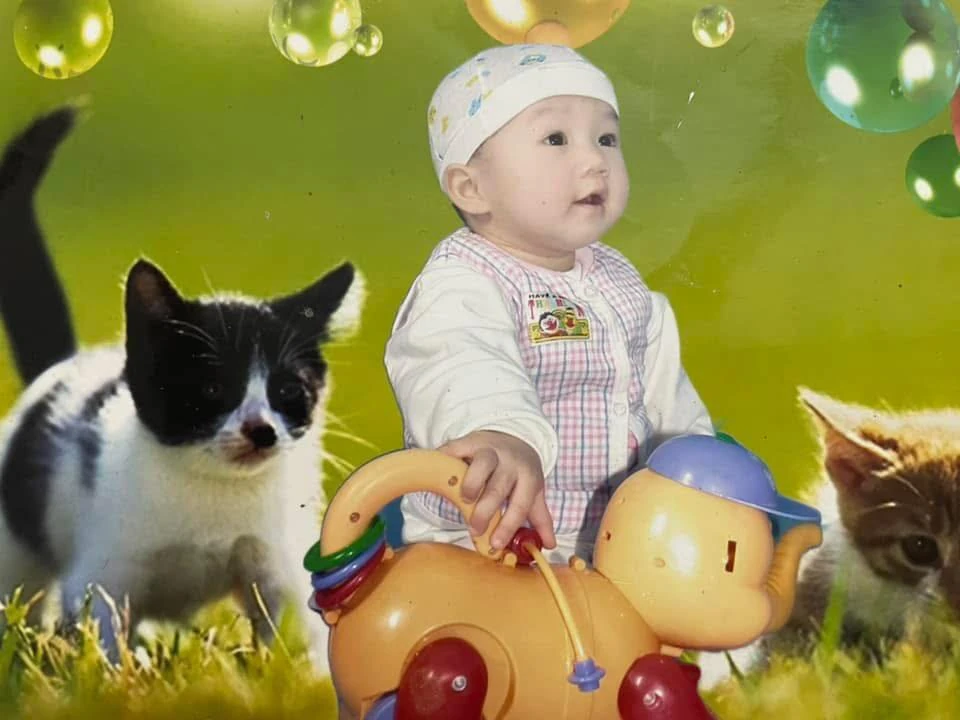 Ảnh con gái khi còn nhỏ ngồi trên đồ chơi trẻ em