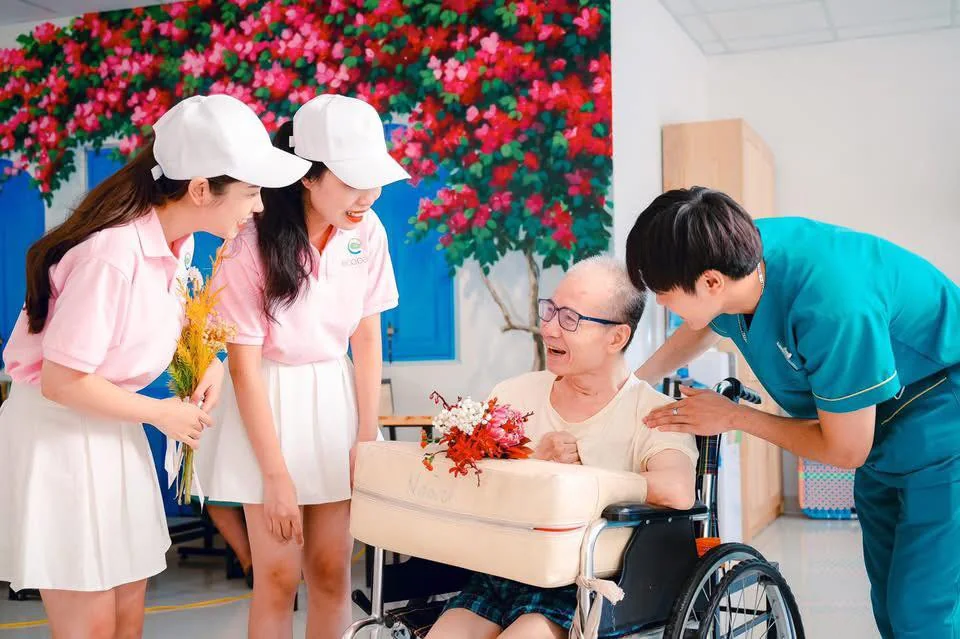 Ông Lê Thế Điệp ngồi xe lăn trò chuyện cùng các cháu điều dưỡng tại Diên Hồng